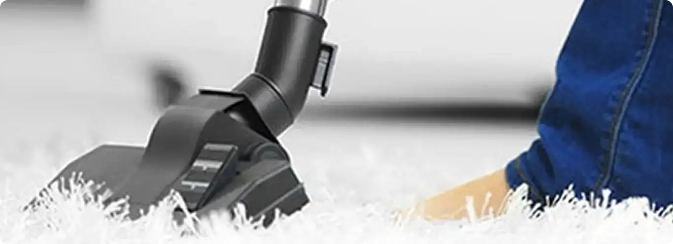 Close-up of a professional vacuuming a white carpet in Owasso.